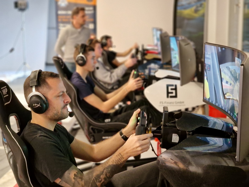 Konzentrierte Fahrer in Reihe von Sim Racing Cockpits