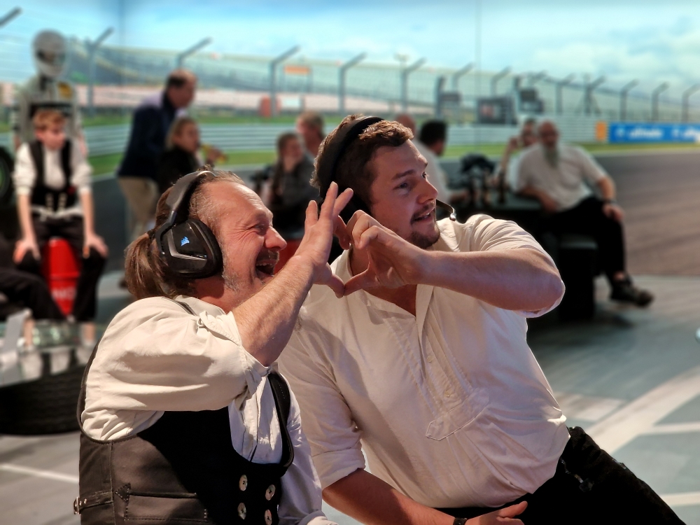 Zwei Teilnehmer mit Headsets haben Spass im Cockpit